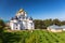 Shining cupola of orthodox monastery in summer day with car and graveyard