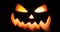 Shining jack-o-lantern. Halloween pumpkin with scary face isolated on the black background