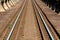 Shining metal railway tracks mounted with rows of strong industrial size bolts to old rusted railway bridge leading to railway