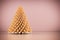 Shining modern Christmas tree on rose gold wall background.
