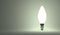 Shining torpedo light bulb on gray