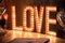 The shining word Love in an interior. Huge letters cost Love from bulbs on a floor