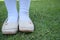 Shinny footwear on the grass. Girl with beautiful shoes. Leather shoes isolated on a grass