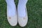 Shinny footwear on the grass. Girl with beautiful shoes. Leather shoes isolated on a grass. Top view of shoe pair.