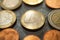 Shiny 1 euro coins and some others around, close up on a glass table