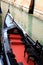 Shiny black and red gondola in Venetian canal