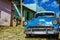 Shiny blue classic old American car and typical colorful colonial buildings in Trinidad