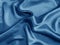 Shiny blue crumpled fabric. Wavy cloth background