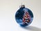 Shiny Blue Holiday Ornament Reflects Brightly Lit Colorful Christmas Tree