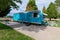 Shiny blue travel trailer on a concrete pad with bicycles