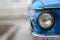 Shiny blue vintage car. Detail view of the headlight. Retro car. Front light. Retro automobile scene. Circle headlamp