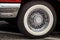 Shiny chrome spoked wheel disk with painted in white tire of red old timer luxury sports car