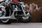 Shiny chromed retro fishtail exhausted pipes of luxury motorcycle. Brick wall with defocused graffiti in background