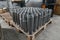Shiny circular precision stainless steel industrial machine parts arranged in rows on pallet. Steel products to