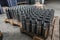 Shiny circular precision stainless steel industrial machine parts arranged in rows on pallet. Steel products to