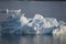 Shiny craggy blue antarctic iceberg in calm water