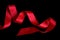 Shiny decorative red satin ribbon, isolated. Scarlet tape, design element