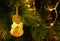 Shiny Gold Cello Shaped with Ribbon Bow Christmas Ornament Hanging on Sparkling Christmas Tree