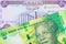 A shiny, green 10 rand bill from South Africa paired with a purple fifty dinar bill from Iraq.