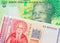 A shiny, green 10 rand bill from South Africa paired with a red and white one lev bank note from Bulgaria.