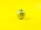 Shiny green apple on bold yellow background