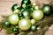 Shiny green christmas baubles closeup macro and tree