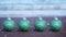 Shiny green Christmas tree balls on sea beach close view