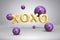 Shiny metal gold letters XOXO and bright flying purple violet balloons spheres on festive background with confetti for Valentines
