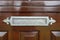 Shiny metal postbox on a brown old-fashioned wooden door, classic design close-up