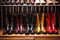 shiny polished boots in a row on shoe rack