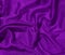 Shiny purple crumpled fabric texture. Elegant wavy cloth background