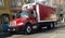 shiny red refrigerated delivery truck park in urban neighborhood