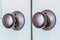 Shiny round doorknobs of a wooden double door at the entrance of a bedroom