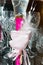 The shiny satin fabric folded in the form of a pink rose, decorative candle with white feather, wedding abstract background