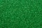 Shiny sequin fabric. Sparkle green texture, dark glitter background. Shimmering surface of textile. Abstract glister pattern.