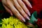 shiny sparkling nude nails on the background of multi-colored colorful flowers