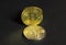 Shiny stack bitcoin coins on black paper textured background, close up view