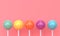 Shiny sweet multicolored lollipops with stick on pink background. 3d rendering