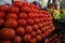 Shiny tomatos neatly put in a large pile at the fruit market