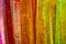 Shiny uneven vertically striped colorful background of pink red orange yellow and green