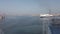 Ship approaching to dock and seagulls fly over the blue sea with harbor skyline