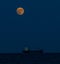 Ship on the Atlantic Ocean with the full moon in the sky in the evening