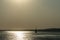 A ship on a background of a silver calm Black Sea at sunset.