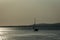 A ship on a background of a silver calm Black Sea at sunset. The sunny path on the water makes the landscape peaceful