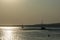 A ship on a background of a silver calm Black Sea at sunset. The sunny path on the water makes the landscape peaceful