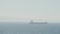 Ship on foggy beach with sun. Action. Single ship in foggy sea on background of coast. Foggy day at sea with lone ship