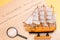 Ship made of wood and fabric handmade on the background of an excerpt from a copy of the document of 1776 on the signing