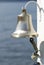 Ship metal bell with rope on a white hook