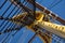 Ship rigging, mast and ropes against a blue sky