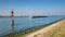 Ship sailing on the New Waterway along industries and wind turbines.